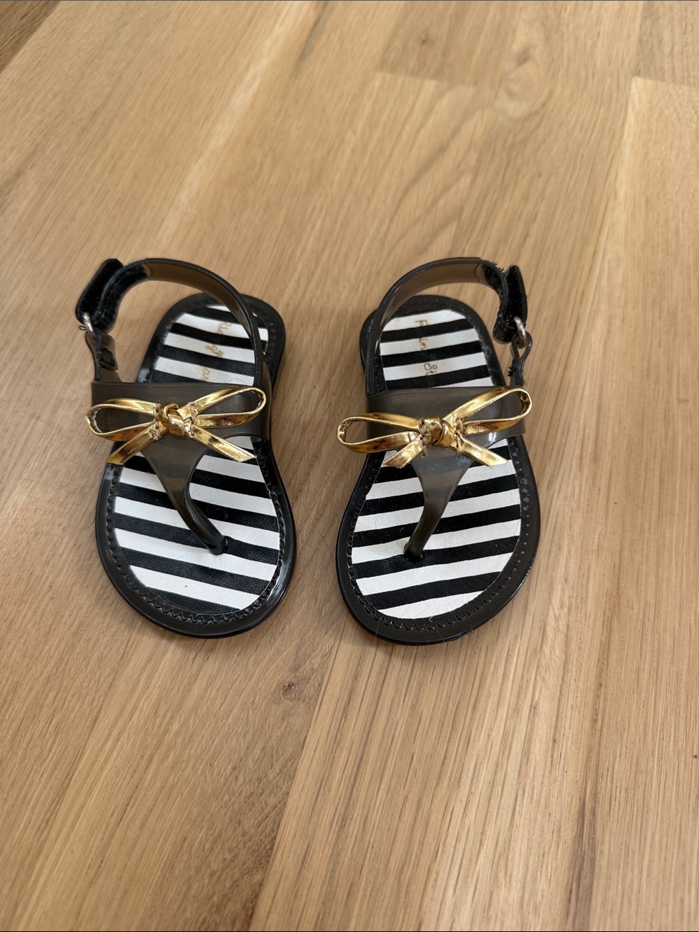 Rising Star Black Sandals with Gold Bow and Striped Footbed